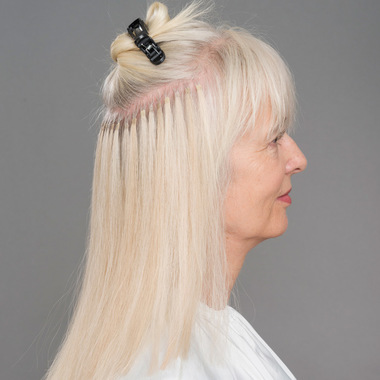Bogenförmig eine Haarpartie über den gesamten Hinterkopf abtrennen:  (© © Great Lengths)