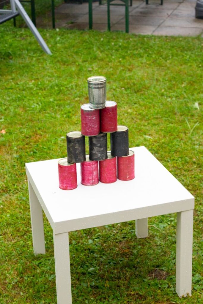 Dosen auf einen weißen Tisch pyramidenfeurmig aufgebaut.