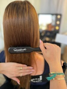 Bürstenaufnahme: Hand hält eine Bürste am langen, glatten Haar