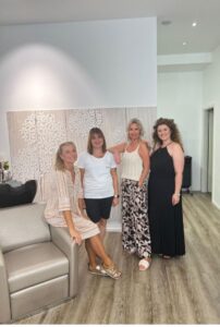 Gruppenfoto: Vier Frauen stehen in einem Innenraum zusammen