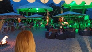 Event am Abend mit grüner Beleuchtung und Personen im Lounge-Bereich