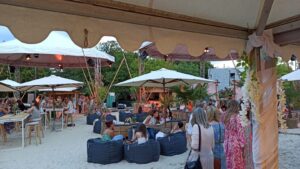 Publikum und Lounge-Bereiche auf der Sandfläche beim Event“