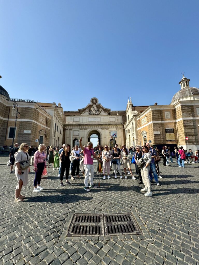 Teilnehmergruppe bei einer Stadtführung durch Rom auf einem historischen Platz.