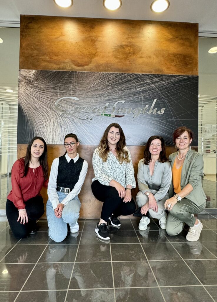 Gruppenfoto von Teilnehmerinnen der Führung vor dem Great-Lengths-Logo im Eingangsbereich der Produktionsstätte in Nepi.
