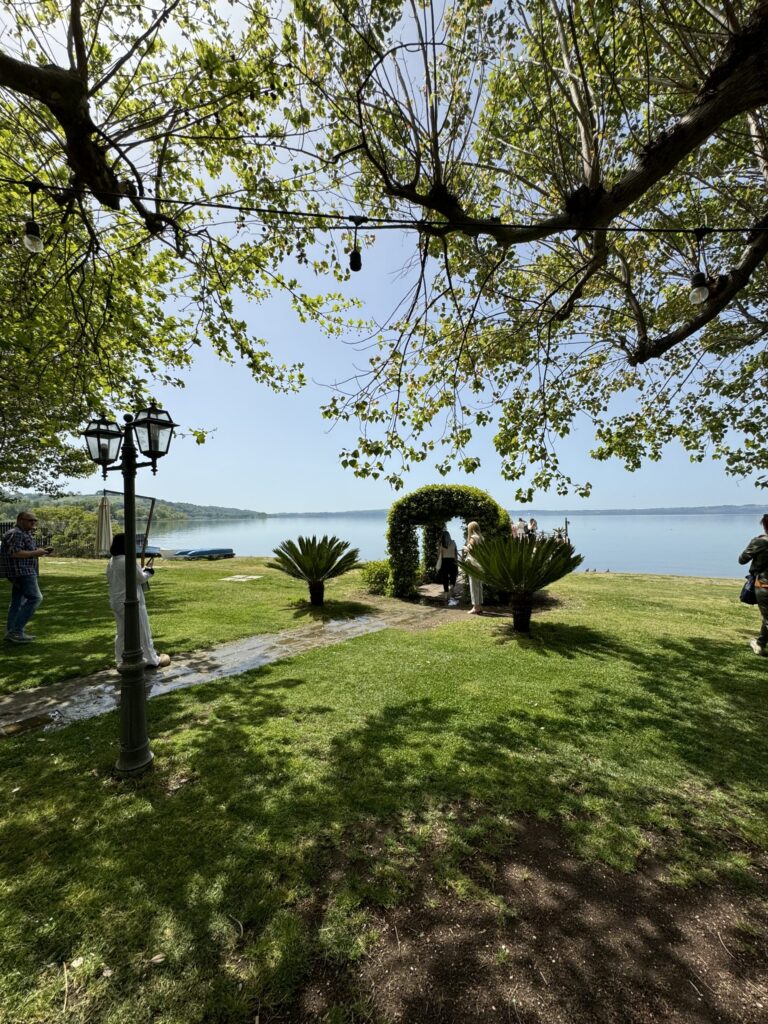 Idyllischer Blick durch Bäume auf den See und die gepflegte Grünanlage.