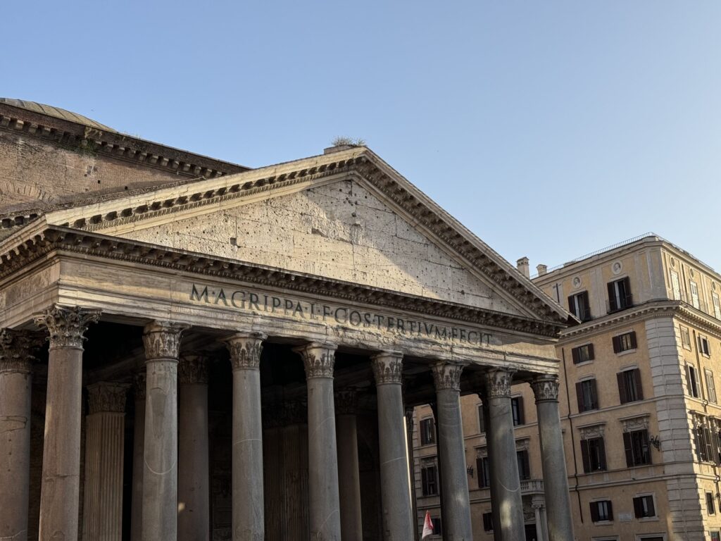 Außenansicht des Pantheon in Rom mit markanter Säulenfront unter klarem Himmel.