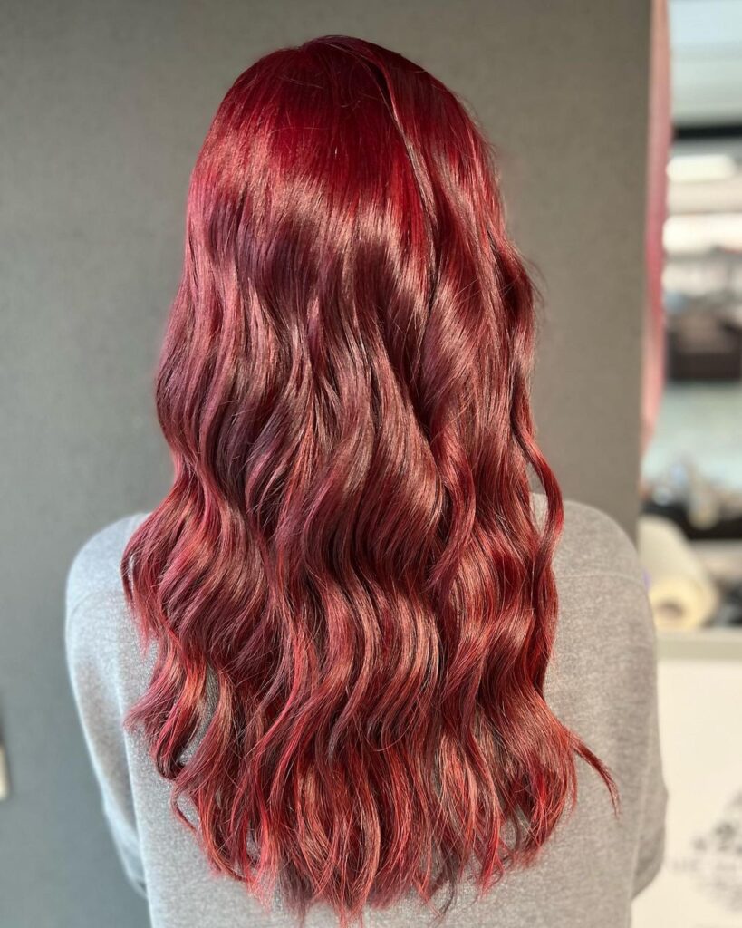 Rückansicht von welligem Haar in warmem Rotton mit sanften Wellen und gleichmäßigem Glanz.