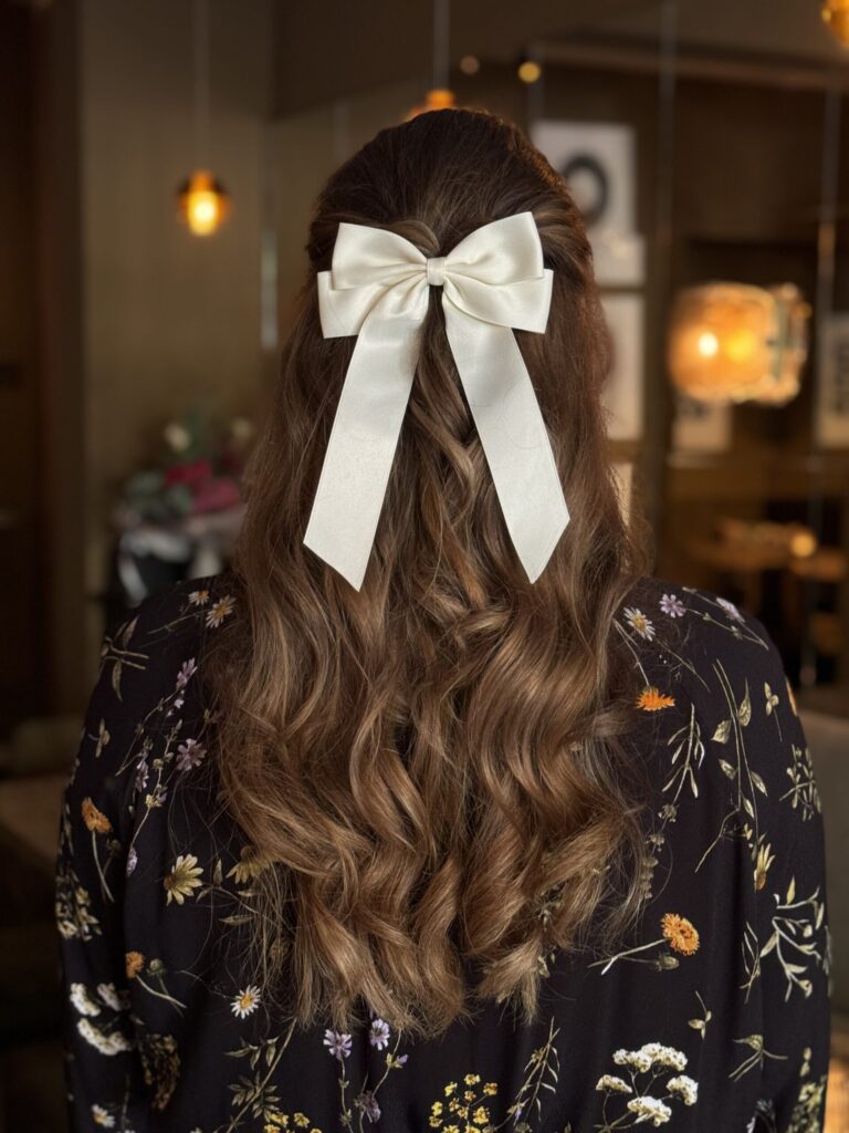 Lange, gewellte Haare mit Schleifen-Haarspange von Great Lengths, stilvoller Akzent für festliche Anlässe.